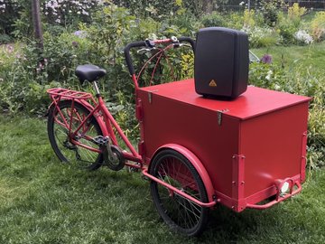 Rotes Lastenrad mit Lautsprecher auf der Ladebox